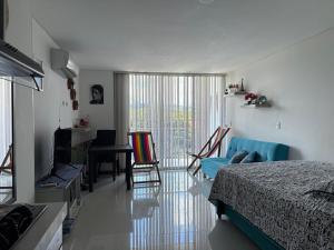 a bedroom with a bed and a living room at Lindo Apartaestudio in Ricaurte