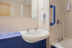 a bathroom with a white sink and a mirror at Days Inn Magor in Magor +24 photos