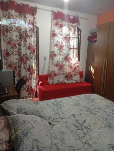 a bedroom with a bed and a red couch at Casa aconchegante in Ouro Preto +7 photos