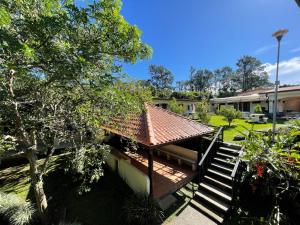 a building with a roof and stairs in a yard at La Dehesa B&B en San Joaquín de Flores in Heredia