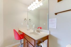 La salle de bains est pourvue d'un lavabo et d'une chaise rouge. dans l'établissement 9 Mi to Trilith Studios Gem in Fayetteville!, à Fayetteville 24 autres photos