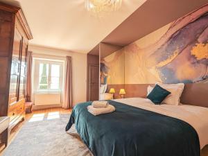 a bedroom with a large bed with a painting on the wall at Maison de maître avec jardin, spa et parking au cœur de Châteauroux - FR-1-591-322 in Châteauroux