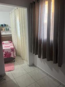a room with curtains and a tiled floor at Kitnet Luar in São Thomé das Letras