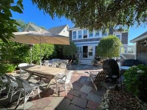 a patio with a table and chairs and an umbrella at Beach Haven Belle -OI Collection in Beach Haven