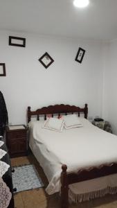 een slaapkamer met een groot bed met witte lakens bij El parque in Vaqueros