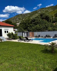 a house with a swimming pool with a mountain in the background at House and pool BajNa in Mostar