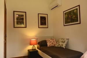 a bedroom with a bed and a lamp and pictures at Villa Le Due Spiagge in Chia