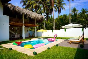 einen Hinterhof mit einem Pool mit Schlauchbooten und einem Haus in der Unterkunft Villa Nakär - Oceanfront Luxury Villa in Playa Amatecampo, El Salvador in La Esmeralda
