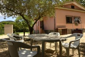 a table and chairs in front of a house at Villa Le Due Spiagge in Chia