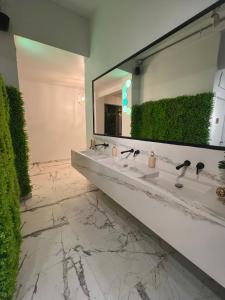 a bathroom with two sinks and a large mirror at 1912 Boutique Hotel in Cayey
