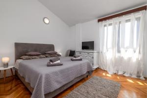 une chambre blanche avec un lit et une télévision dans l'établissement Family friendly house with a swimming pool Krnica, Marcana - 24375, à Krnica