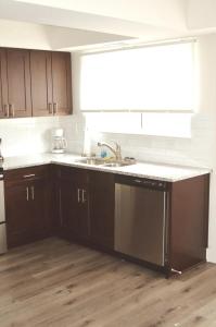 夏洛特312C State St Stylish 2BR Near Uptown Your Perfect Home Base!的厨房配有棕色橱柜和水槽