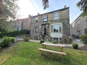 a bench in the grass in front of a building at Exquisite 2 Bedroom Apartment in Sheffield