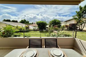 a balcony with a table and chairs and a view at Vaiana City Apartment - relaxing downtown Papeete - garden view AC - WiFi in Papeete