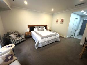a bedroom with a large bed and a couch at Spacious City Studio Stay - Modern with Extras in Auckland +14 photos