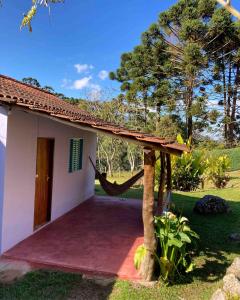 a house with a hammock outside of it at Recanto da Paz - Vale da Prata in Bocaina de Minas