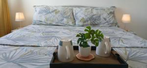 a bed with two vases and two plants on a tray at Mike's Place at Marina Spatial in Dumaguete +67 photos