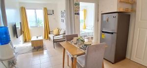a kitchen and living room with a table and a refrigerator at Mike's Place at Marina Spatial in Dumaguete