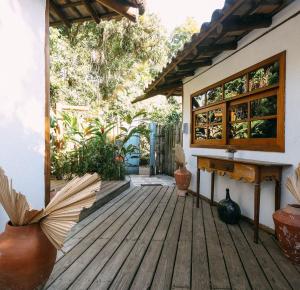 a wooden deck with an open door to a house at Pousada Ó Paí, Ó in Caraíva