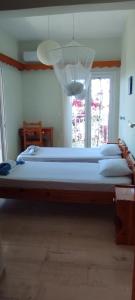 a large bed in a bedroom with a chandelier at angelos aparts11 in Arillas
