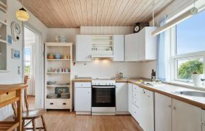a kitchen with white cabinets and a sink at 5 Bedroom Awesome Home In Vestervig in Vestervig