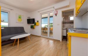 a kitchen and living room with a couch and a table at Nice Apartment In Povljana With Wifi in Povljana
