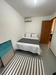 Lindo Apartamento - 600 metros da Praia de Itaparica في فيلا فيلها: غرفة نوم بسرير ودهان على الارض