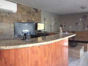 un bar en una habitación con TV en la pared en Hotel Jardin en Heroica Caborca