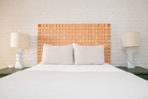 a bedroom with a white bed with two lamps at Captains Courtyard - Heart of Historic Downtown Wilmington - 48 Firepit - Turf Yard in Wilmington