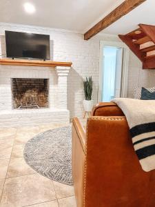 a living room with a couch and a fireplace at Captains Courtyard - Heart of Historic Downtown Wilmington - 48 Firepit - Turf Yard in Wilmington