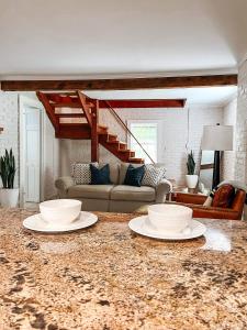 a living room with two white plates on a marble table at Captains Courtyard - Heart of Historic Downtown Wilmington - 48 Firepit - Turf Yard in Wilmington