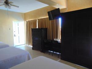 1 dormitorio con 1 cama y vestidor con TV en Hotel Jardin en Heroica Caborca