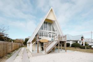 a large white house with a steep roof at The Little Ray - 2 blocks to Beach - Backyard - Walk to Boardwalk in Carolina Beach