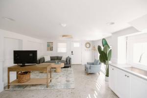 a living room with a couch and a table at The Little Ray - 2 blocks to Beach - Backyard - Walk to Boardwalk in Carolina Beach