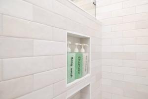 a bathroom with a green soap dispenser in a niche at The Little Ray - 2 blocks to Beach - Backyard - Walk to Boardwalk in Carolina Beach +30 photos