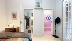 a bedroom with a bed and a pink door at Suíte Exclusiva Charmosa com Varanda Verde - 100m da Paulista in Sao Paulo
