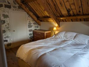 a bedroom with a white bed and a wooden ceiling at Auberge du Vieux Montmagny in Montmagny