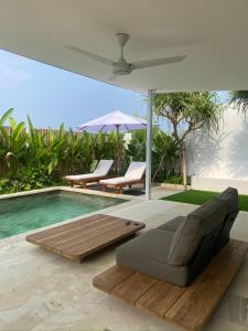 un soggiorno con divano e ombrellone e una piscina di The Blue Zone Villa a Nusa Lembongan Altre 15 foto