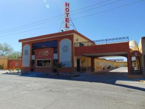 Una calle vacía frente a un edificio con un cartel. en Hotel Jardin, en Heroica Caborca