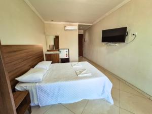 a hotel room with a bed and a flat screen tv at Pousada Morada Azul in Porto De Galinhas