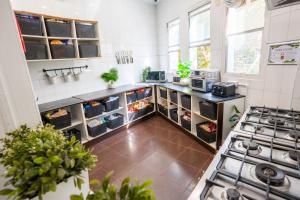 a kitchen with a stove and some plants in it at Mad Monkey Kings Cross in Sydney