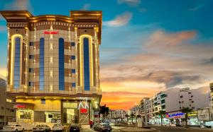a building with cars parked in front of a street at أبهى حياه للشقق المخدومة - إقتصادي in Abha