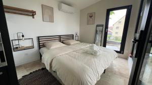 a bedroom with a bed with white sheets and a window at LODGE ESCOVIEN Strasbourg in Eschau +24 photos
