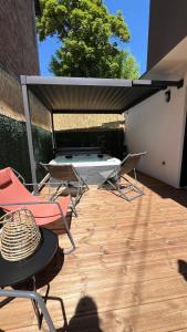a patio with chairs and a table and a grill at LODGE ESCOVIEN Strasbourg in Eschau