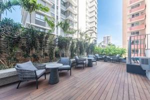 a deck with chairs and tables on a building at Ap novo, perto de Congonhas, com cama queen size in São Paulo