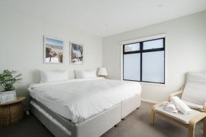 罗斯巴德Villa Morava - Pet-friendly Beachside Comfort的一间带大床和椅子的白色卧室