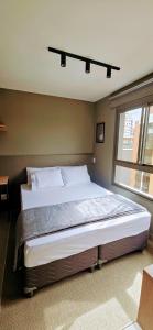 a large bed in a bedroom with a window at Ap novo, perto de Congonhas, com cama queen size in São Paulo +13 photos
