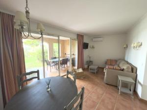 a dining room with a table and a living room at Appartement climatisé en Provence, à deux pas du Golf de Pont Royal - FR-1-658-35 in Mallemort