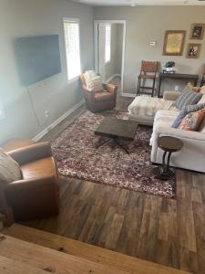 a living room with two couches and a flat screen tv at Charming Renovated Home Near Fayetteville, Rustic Retreat for Families in Raeford