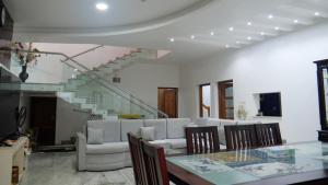 un salon avec un canapé et une table avec des chaises dans l'établissement Dazicor Retreats - Luxury Villa in Kottarakara, 